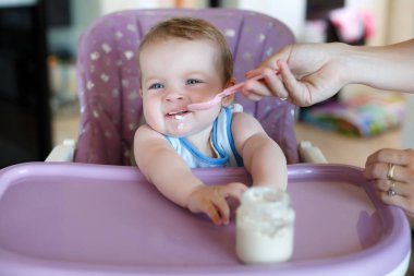 Genç anne çocuk spoon-feeds