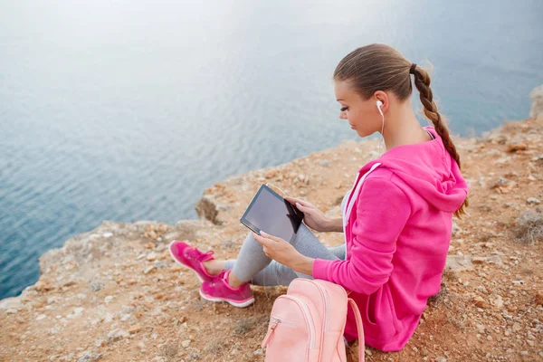 Woman on a rocky beach with a tablet in the spring — Stock Photo, Image
