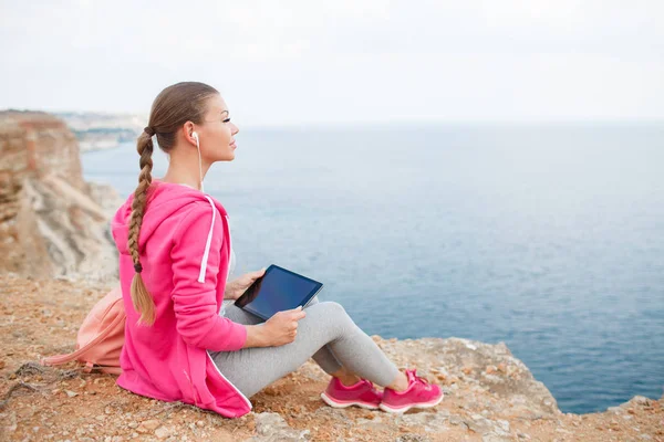 Woman on a rocky beach with a tablet in the spring — Stock Photo, Image