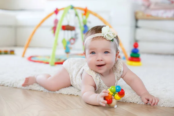 Маленькая девочка играет с игрушками дома на полу — стоковое фото