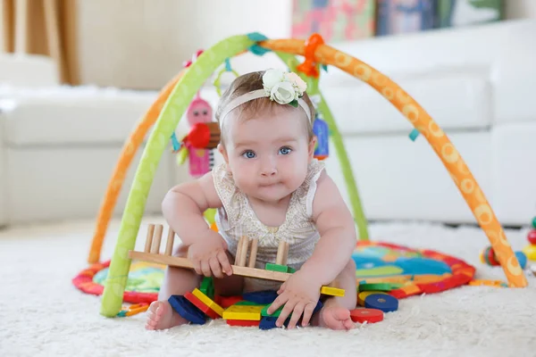Liten flicka som leker med leksaker hemma på golvet — Stockfoto
