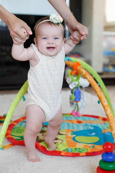 Junge Mutter hilft ihrer Tochter bei ersten Schritten — Stockfoto