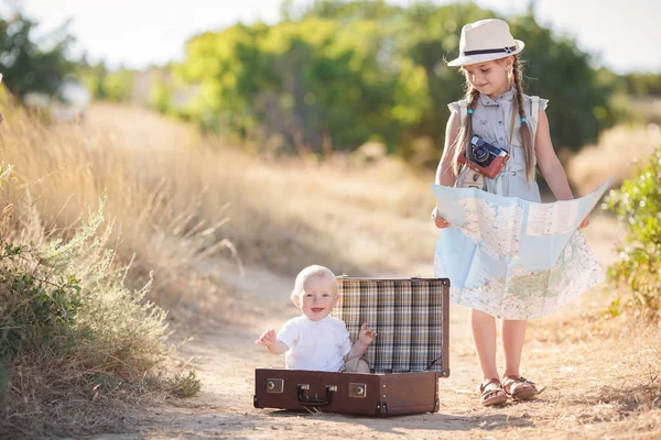 Travel in a suitcase with her older sister — Stock Photo, Image