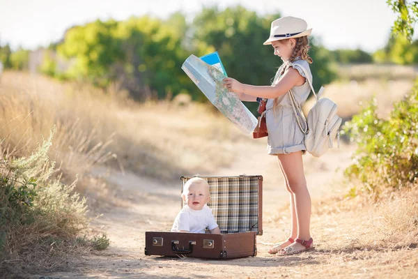 Travel in a suitcase with her older sister — Stock Photo, Image