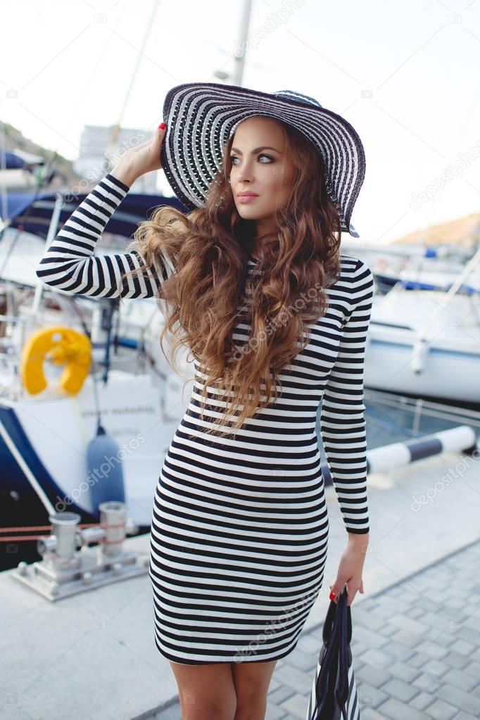 Portrait of beautiful woman in hat on the pier