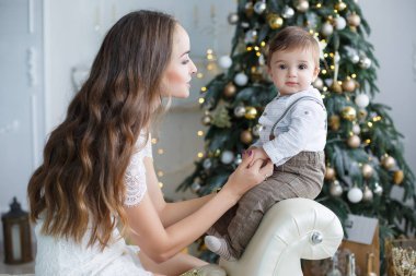 Anne ve genç oğlu evde Noel ağacı yakınındaki