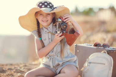 Bir kayanın üzerinde büyük bir şapka ile genç fotoğrafçı