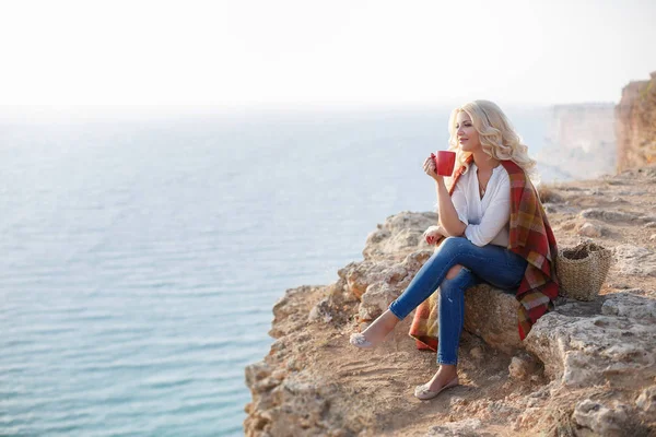 トンガリ岩の上に座って珈琲を飲んで美人 — ストック写真