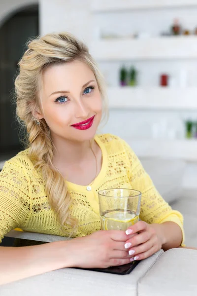 Retrato de una hermosa mujer con un vaso de agua en la cocina —  Fotos de Stock