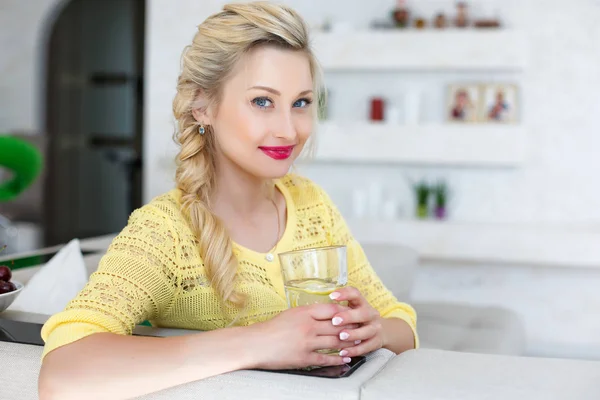Porträtt av en vacker kvinna med ett glas vatten i köket — Stockfoto