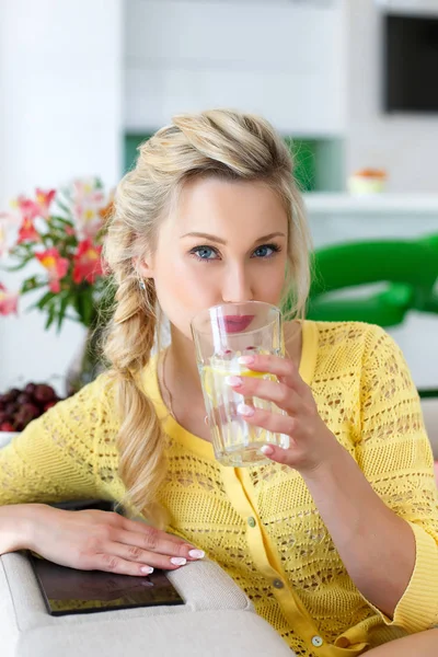 Ritratto di una bella donna con un bicchiere d'acqua in cucina — Foto Stock