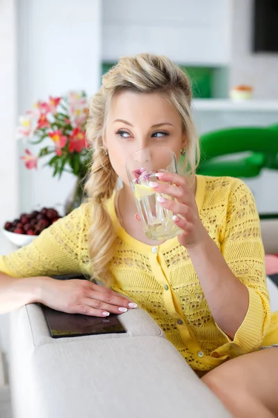 Porträt einer schönen Frau mit einem Glas Wasser in der Küche — Stockfoto