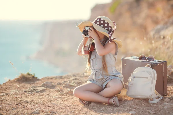 Fotógrafo jovem com um chapéu grande em uma rocha — Fotografia de Stock