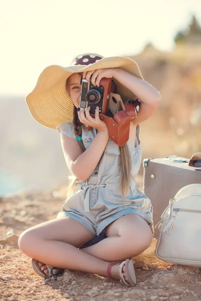 Fotógrafo jovem com um chapéu grande em uma rocha — Fotografia de Stock