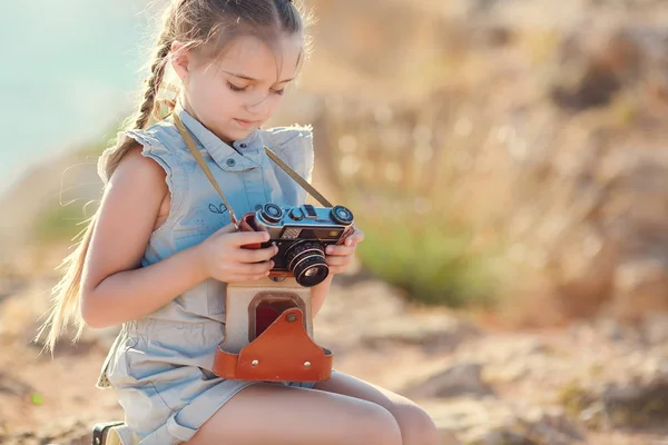 Young photographer with a big hat on a rock — Stock Photo, Image