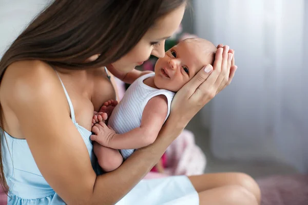 Mãe brincando com bebê recém-nascido sentado no chão — Fotografia de Stock