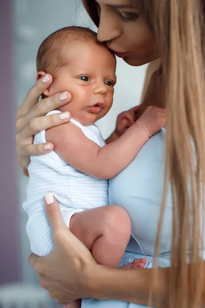 Mladá matka s dítětem v rukou doma v ložnici — Stock fotografie