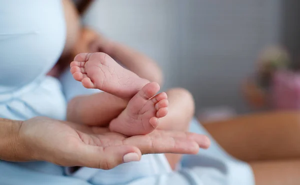 Primer plano de pies de bebé y manos madre — Foto de Stock