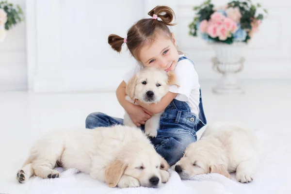 Kleines Mädchen spielt mit Welpen Retriever — Stockfoto