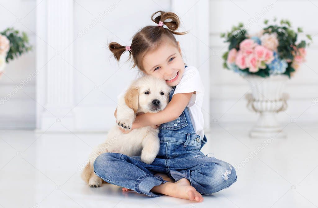 Little girl playing with a Puppy Retriever