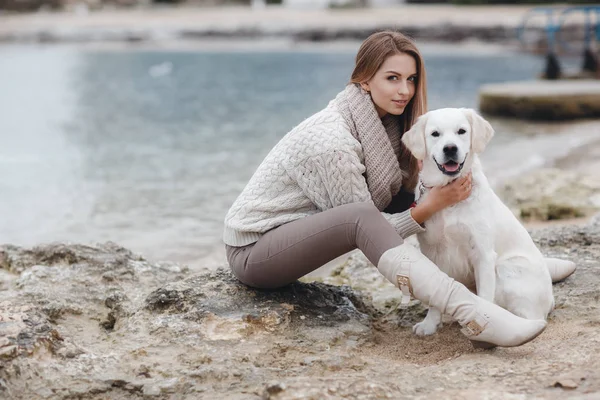 Žena se psem na břehu moře — Stock fotografie