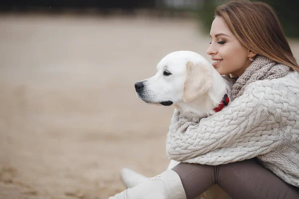 Donna con cane sulla riva del mare — Foto Stock