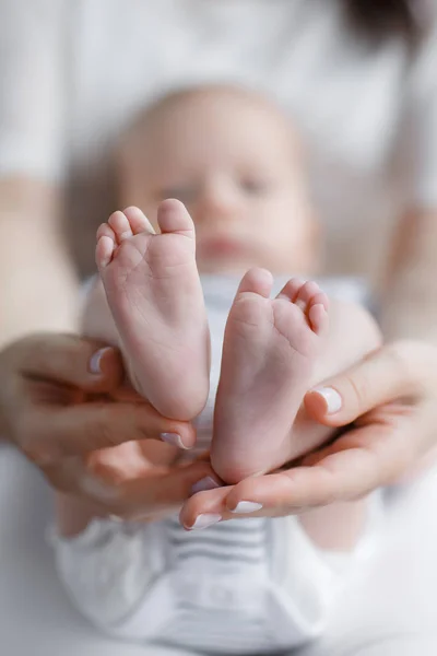 Close-up of mother's hands and baby's feet — Stock Photo, Image