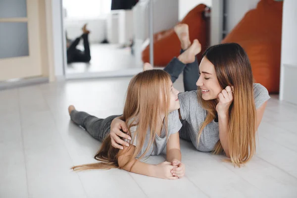 Madre e figlia sdraiate sul pavimento e si guardano a vicenda — Foto Stock