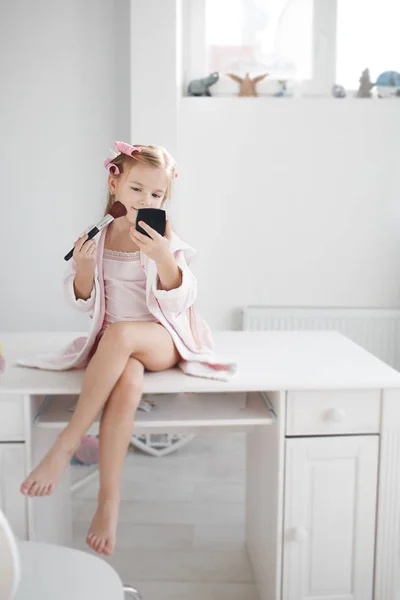 Маленька дівчинка з дзеркалом і пензлем для макіяжу — стокове фото