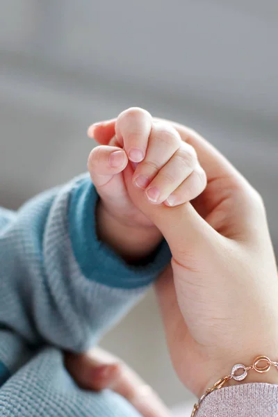 Baby holds mother 's finger — стоковое фото