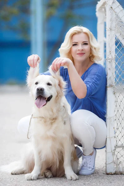 Açık havada güzel köpek oynama ile bir kadın portresi. — Stok fotoğraf