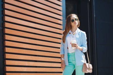 Genç kadın bir şehir sokak üzerinde kağıt bardak kahve içme