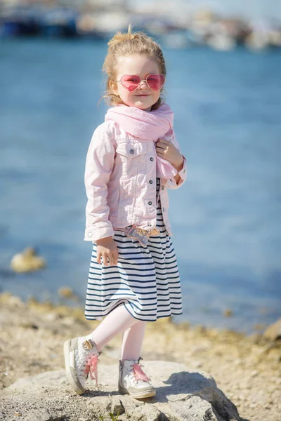 Niña de moda en gafas de sol rosas. El concepto de vacaciones de verano —  Fotos de Stock