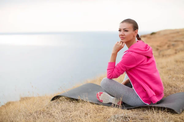 Девушка выполняет расслабляющие упражнения на пляже — стоковое фото