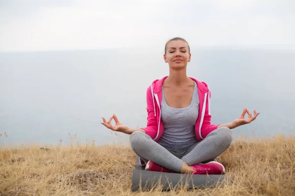 A girl performs relaxing exercises on the beach — Stock Photo, Image