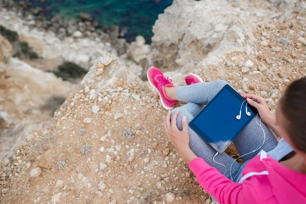 Woman on a rocky beach with a tablet in the spring — Stock Photo, Image