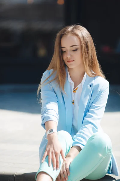 Retrato de una chica en traje azul, sentada cerca de la oficina —  Fotos de Stock