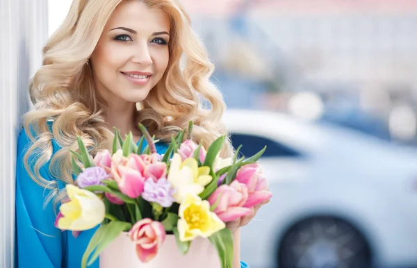 Vacker ung kvinna med blommor bukett på gata. — Stockfoto