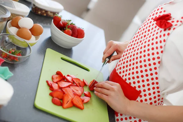 Lächelnde blonde Frau kocht Cupcakes in der Küche — Stockfoto