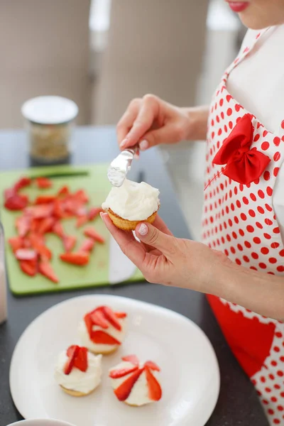 Mujer rubia sonriente cocinando cupcakes en la cocina —  Fotos de Stock