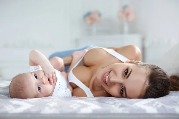 Junge Mutter Bett Liegend Mit Ihrem Neugeborenen Jungen Zusammen Spielen — Stockfoto