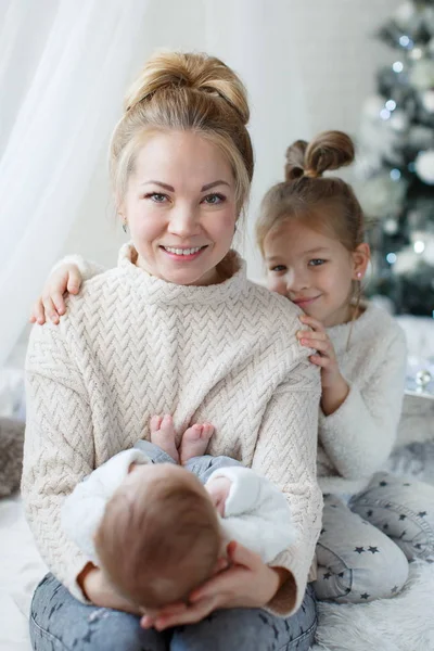 Happy young mom and baby girl in Christmas morning in home