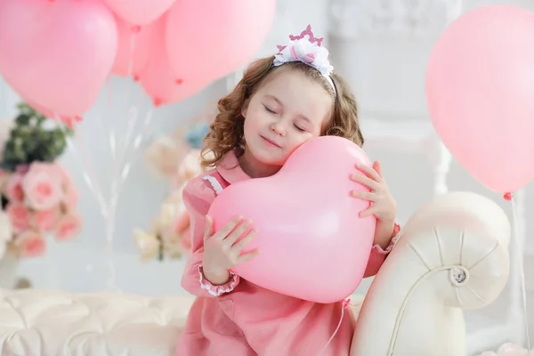長い巻き毛 白タイツ 美しい笑顔とピンクのドレスに身を包んだ 歳の小さな女の子は たくさんのハートの形をしたピンクの風船と大きな明るい部屋で単独します バレンタインやお祝いパーティー — ストック写真