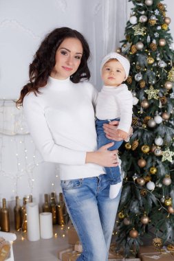 Mutlu Noeller ve mutlu tatil anne ve sevimli kızı kızı hediye ile. Ebeveyn ve çocuklar eğlenmek ve birlikte kapalı Noel ağacının yanında oynayan. Sevgi dolu aile ile oda içinde sunar. Neşeli Noel hediye ve oyuncaklar ile