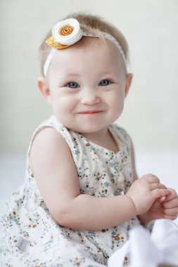 Bir sekiz, dokuz aylık bebek kız mavi gözlü close-up. Yeni doğan çocuk, küçük sevimli gülümseyen ve özenli kız kameraya sürpriz. Aile, yeni hayat, çocukluk kavramı. Noel arifesi