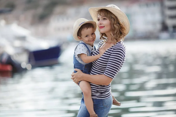 妈妈和小儿子一起呆在外面 坐在船坞边的码头上 年轻妈妈带着孩子散步 妈妈和儿子一起在度假胜地 — 图库照片