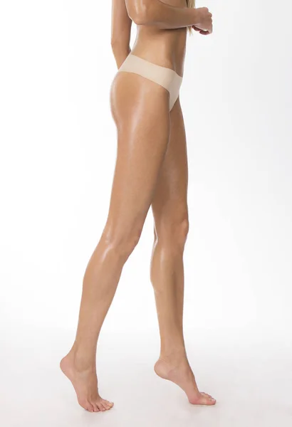 Tanned girl's legs and beige thongs — Stock Photo, Image