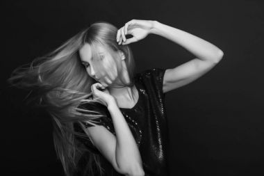 Genç kadın çok güzel uzun uçan saçları ile poz. Monochrom