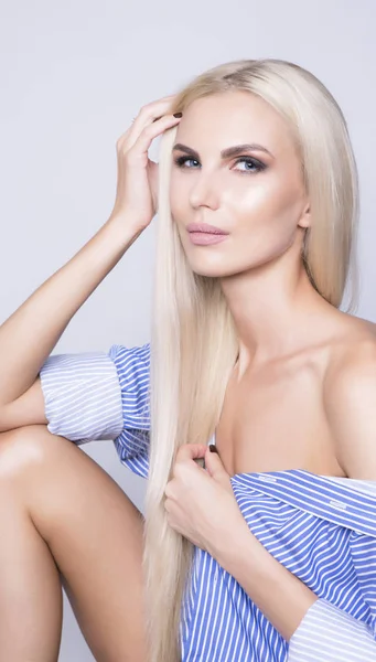 Sexy žena, sedící v business košile. Dlouhé platinově blond vlasy. — Stock fotografie