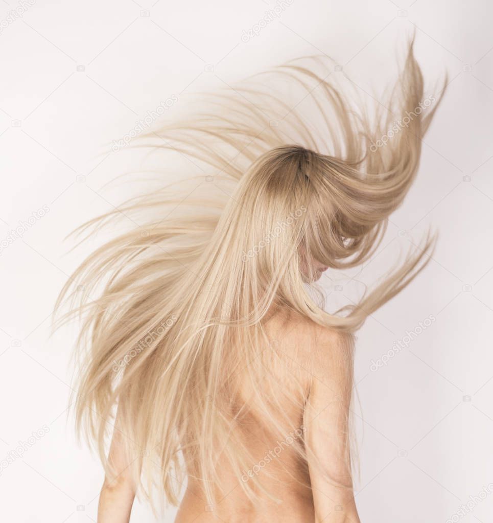 Flying long platinum blonde hair over white background, anonymous studio shot.